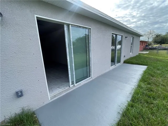 View of property exterior with a patio area and a yard