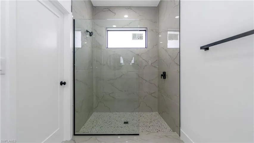 Primary bathroom featuring a marble finish shower