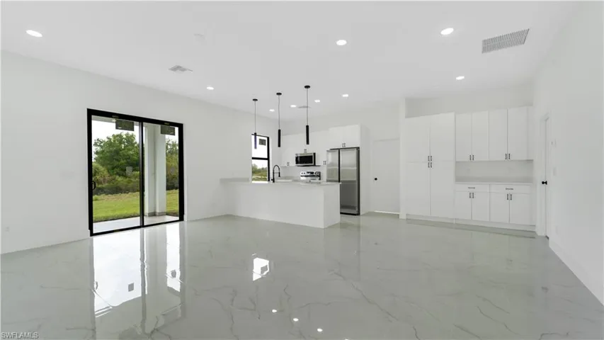 Living room with recessed lighting, visible vents, marble finish floor, and a sink