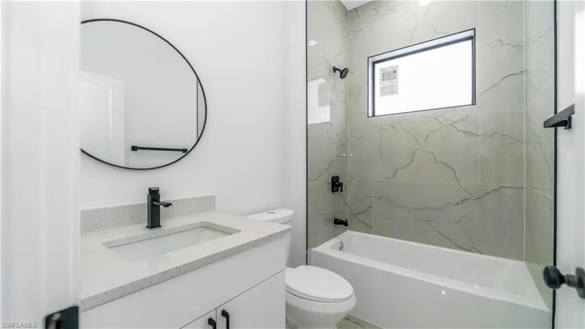 Guest bathroom featuring shower / bathing tub combination, toilet, and vanity