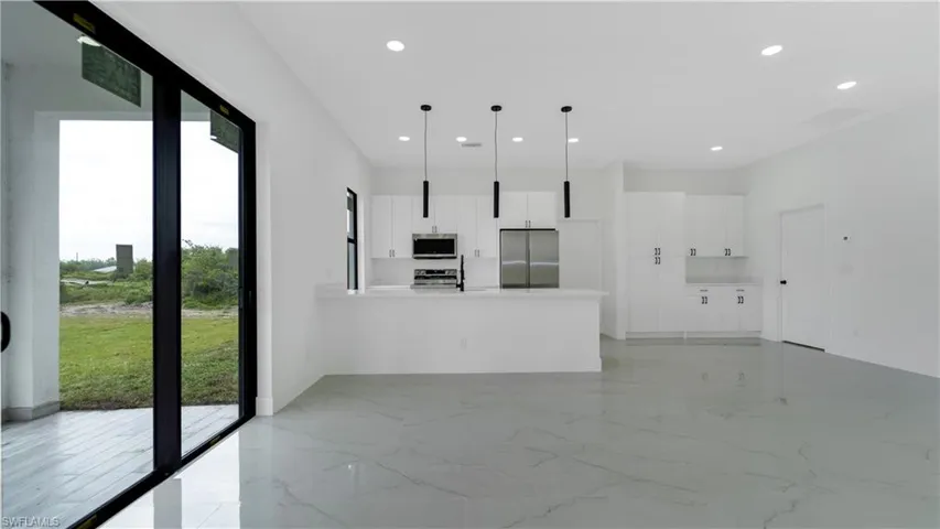 Living room with recessed lighting, a healthy amount of sunlight, and marble finish floor