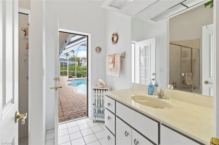 Bathroom featuring a stall shower, a garden tub, double vanity, and healthy amount of natural light