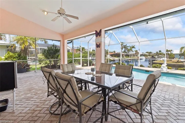 Outdoor pool featuring a water view, glass enclosure, and a patio area