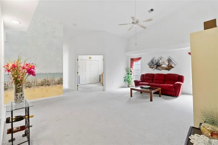 Home office featuring light carpet, a wainscoted wall, and a ceiling fan