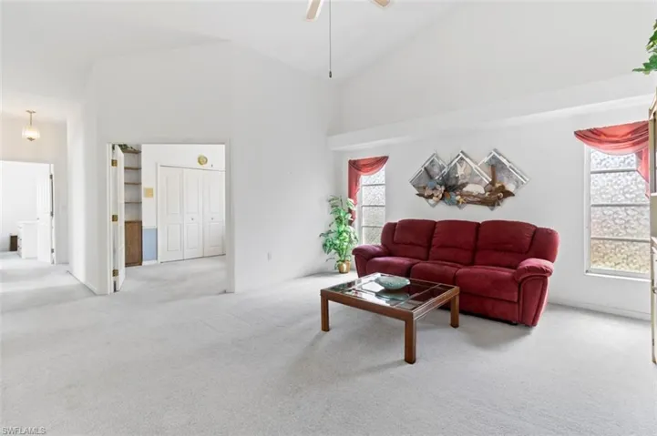 Carpeted home office featuring ceiling fan, french doors, and a wainscoted wall