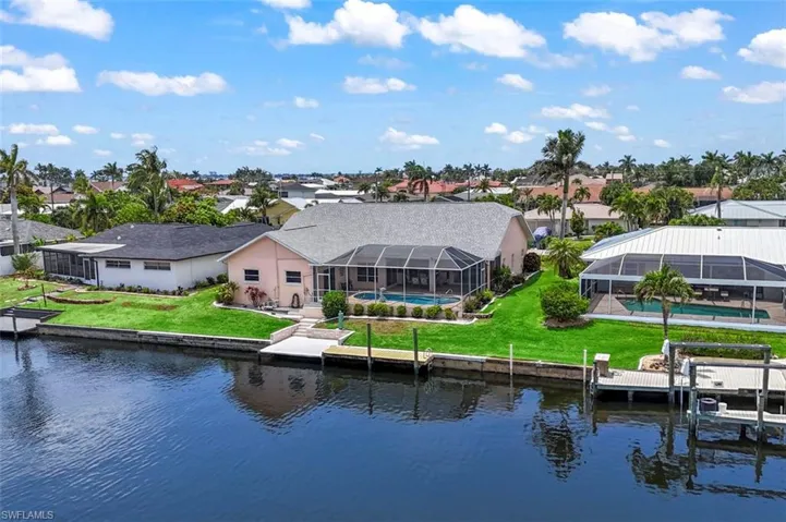 Rear view of property featuring a water view, an outdoor pool, and a yard