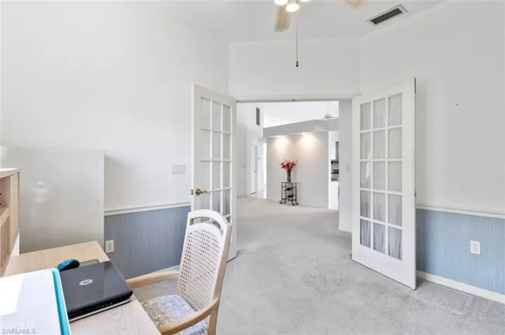 Unfurnished bedroom with light colored carpet, a high ceiling, and connected bathroom