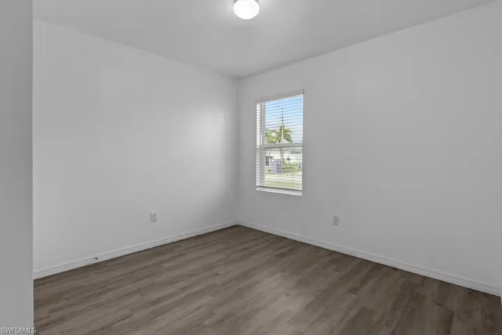 Unfurnished room with dark hardwood / wood-style flooring