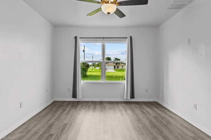 Empty room with ceiling fan and light hardwood / wood-style flooring