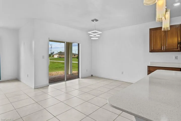 Unfurnished dining area featuring a chandelier and light tile patterned floors