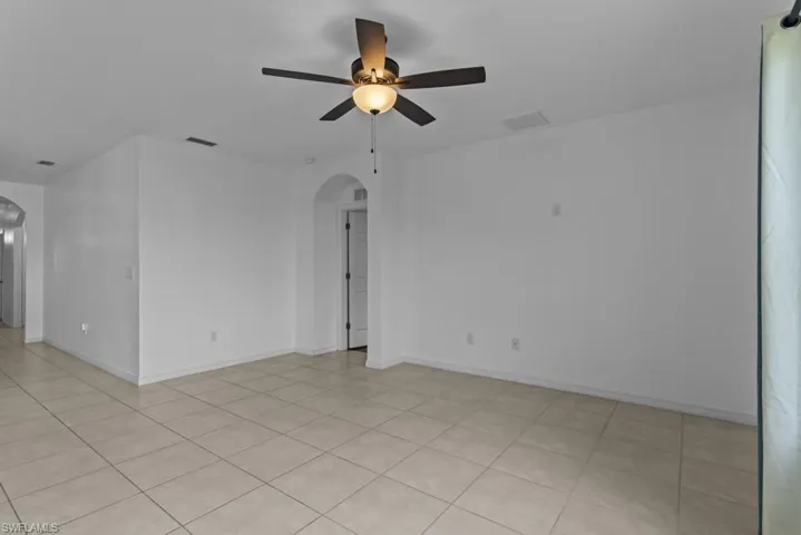 Empty room featuring ceiling fan and light tile patterned floors