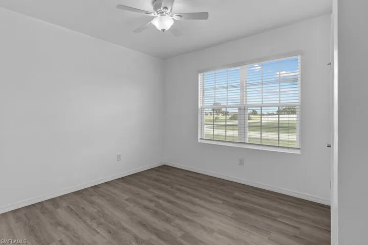 Empty room with ceiling fan and wood-type flooring