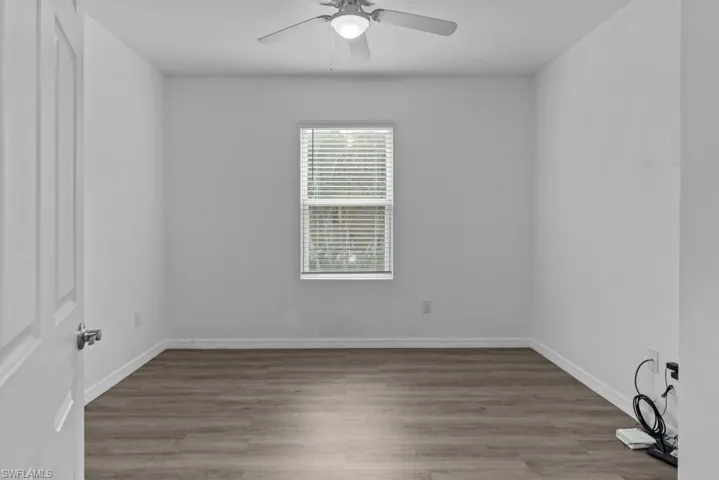 Empty room with ceiling fan and hardwood / wood-style flooring