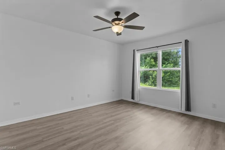 Empty room with light wood-type flooring and ceiling fan