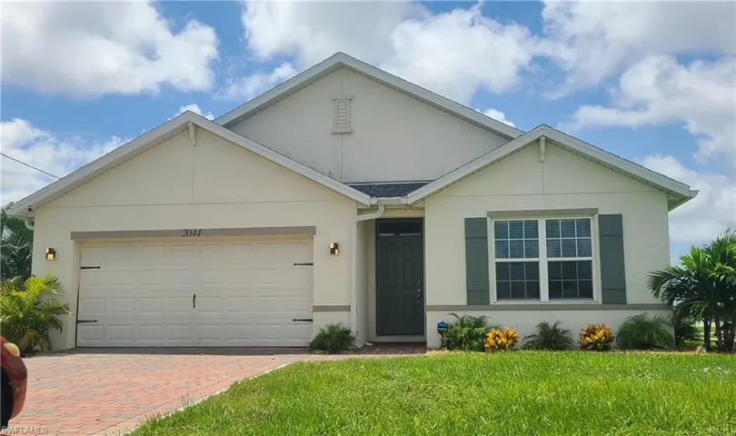 Ranch-style house featuring a garage and a front yard
