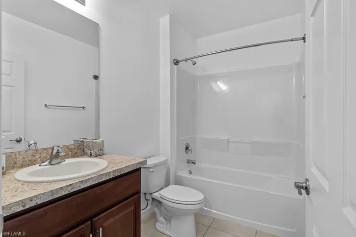 Full bathroom with vanity, toilet, bathtub / shower combination, and tile patterned floors