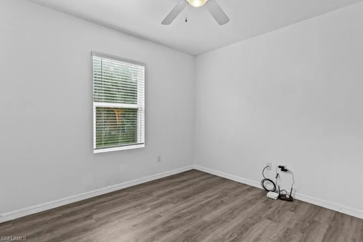 Spare room with ceiling fan and wood-type flooring