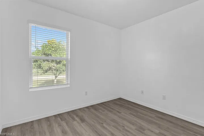 Empty room with plenty of natural light and hardwood / wood-style floors