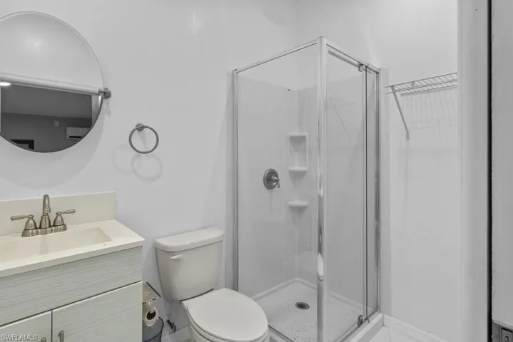 Bathroom with a shower with shower door, toilet, and vanity