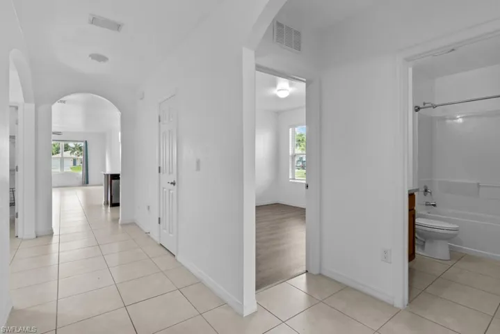 Hall with a wealth of natural light and light tile patterned floors