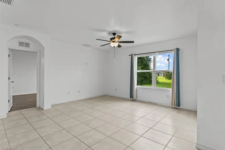 Unfurnished room featuring ceiling fan and light tile patterned flooring