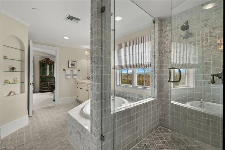 Bathroom with a bath, ornamental molding, vanity, recessed lighting, and light colored carpet