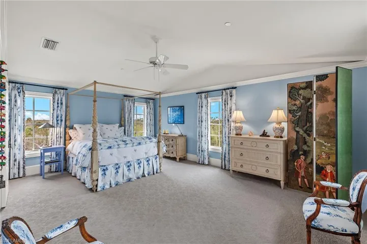 Bedroom featuring carpet floors, lofted ceiling, and a ceiling fan