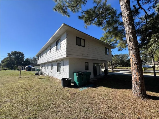 View of property exterior featuring stucco siding and a lawn