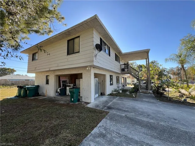 View of property exterior featuring stucco siding and stairs