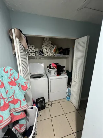 Laundry room with light tile patterned floors and independent washer and dryer