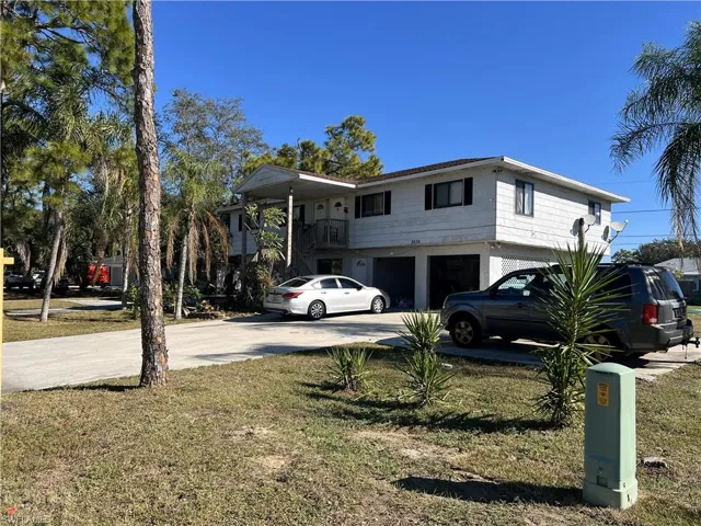 View of front facade featuring driveway, an attached garage, and a front yard