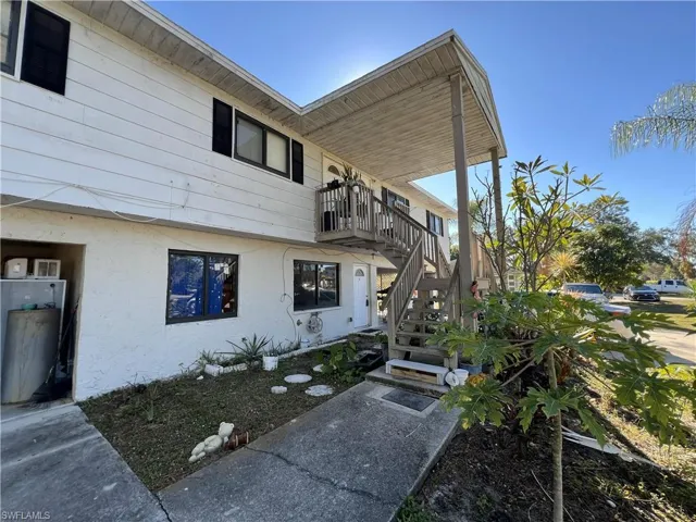 View of property exterior featuring stairs and stucco siding