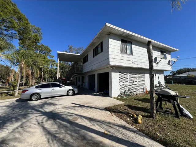 View of side of home featuring driveway, stucco siding, and an attached garage