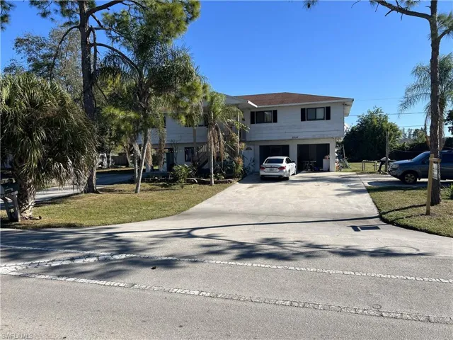 View of front of property with driveway, a garage, and a front lawn