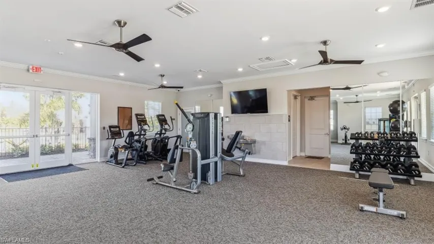 Workout area with ceiling fan, ornamental molding, and plenty of natural light