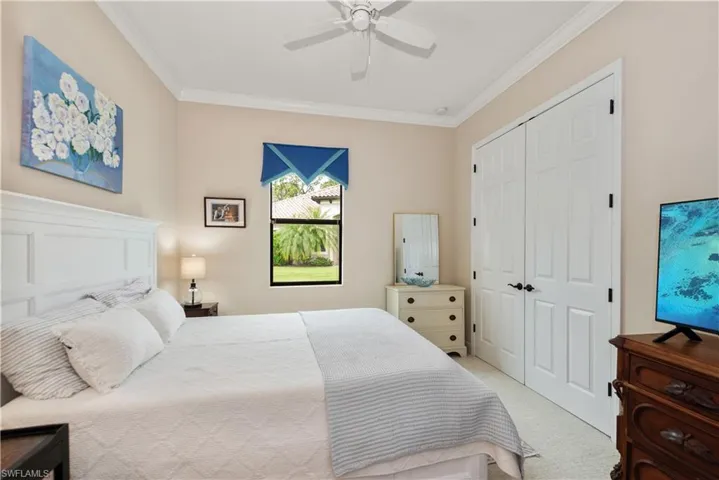 Carpeted 2nd bedroom with crown molding, ceiling fan, and a closet