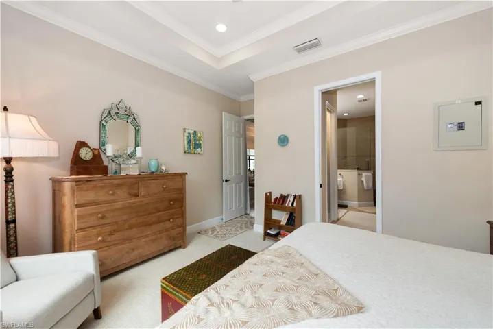 Bedroom featuring recessed lighting, ornamental molding, carpet flooring, a raised ceiling, and on-suite bathroom