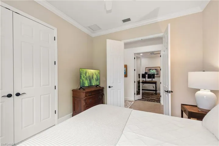 Carpeted 2nd bedroom with crown molding, ceiling fan, and a closet