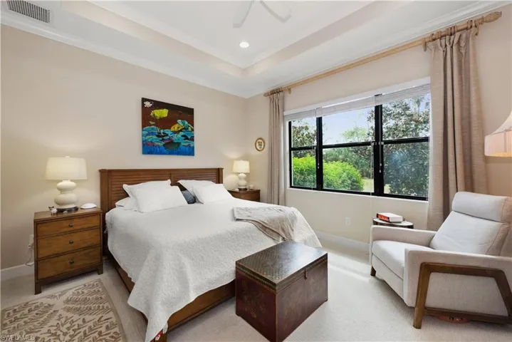Carpeted bedroom with a raised ceiling, a ceiling fan, recessed lighting, and ornamental molding