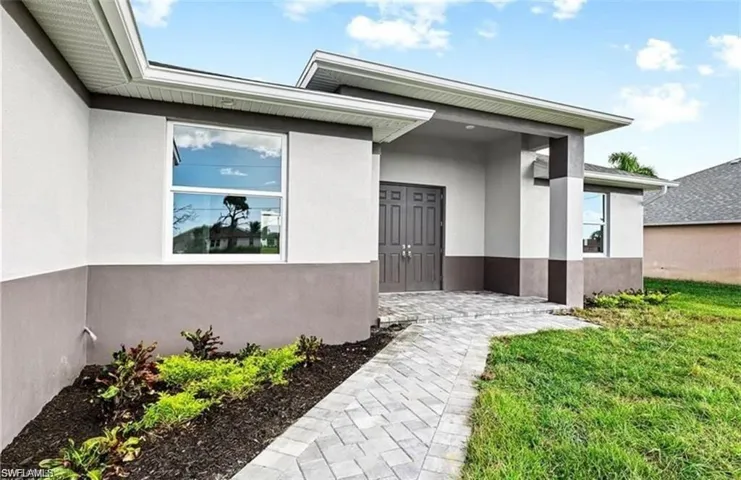 Property entrance with stucco siding and a yard