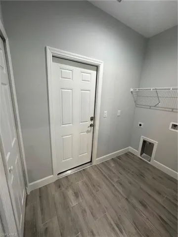 Laundry room featuring wood finish floors and electric dryer hookup