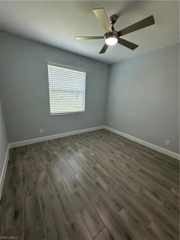 Unfurnished room with wood finish floors and a ceiling fan