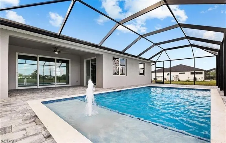 Swimming pool featuring a sunroom, a patio area, and glass enclosure