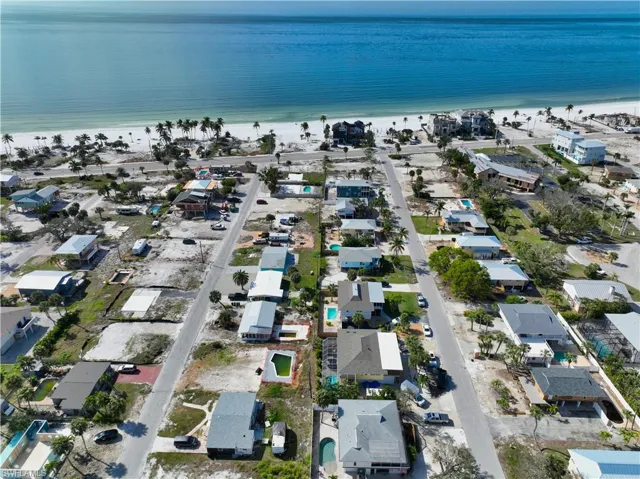 Birds eye view of property featuring a water view and a beach view