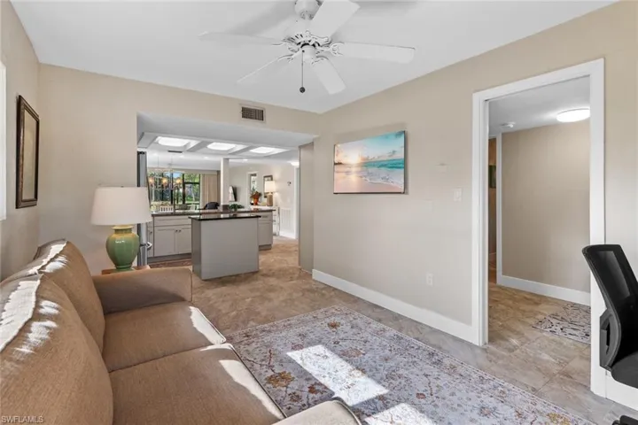 Living room with light tile patterned flooring and ceiling fan