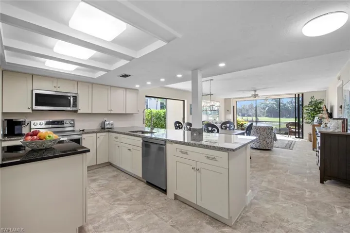 Kitchen with appliances with stainless steel finishes, sink, light tile floors, and kitchen peninsula
