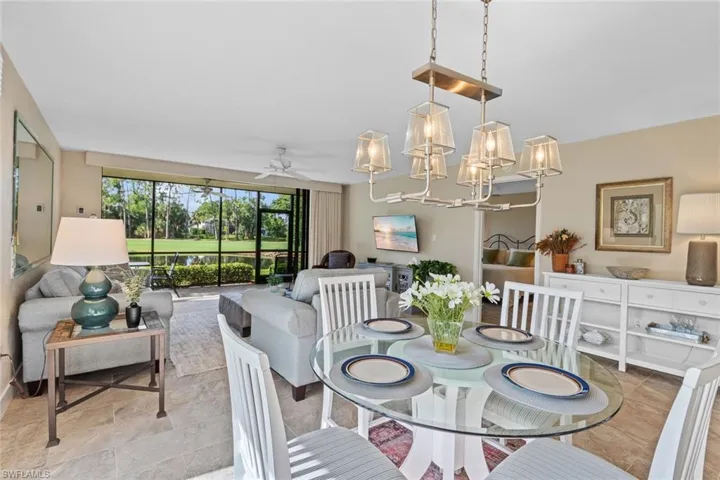 Tiled dining room with ceiling fan with notable chandelier