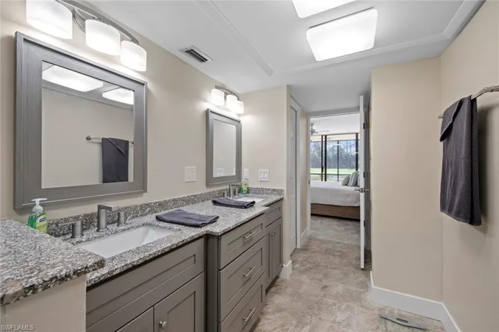 Bathroom featuring tile floors and dual vanity