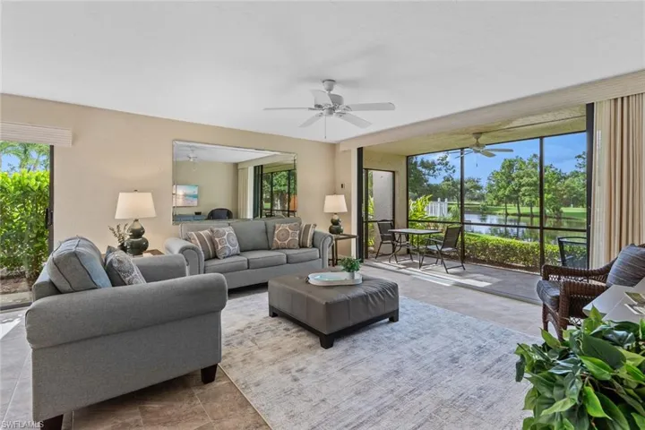 Living room featuring a water view, a wealth of natural light, ceiling fan, and tile patterned flooring