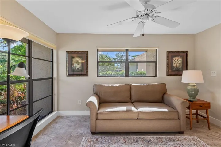 Living room with ceiling fan and tile patterned floors